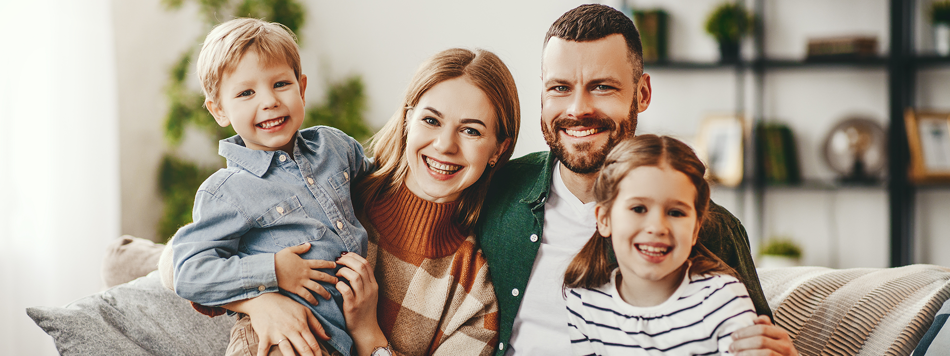 Happy family of four on sofa